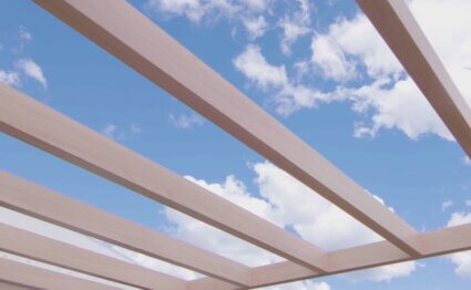 decopost pergola in a decwood curly birch finish with a skye background.